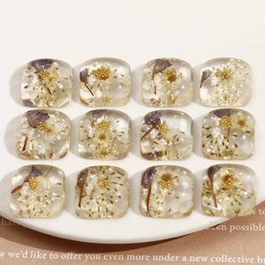 Détail de breloques en résine avec fleurs séchées et perles pour bijoux et accessoires