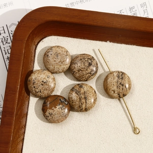 Macro-opname van onregelmatige natuurstenen kralen met marmertextuur en metalen pen voor DIY