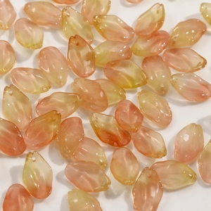 Detalle macro de cuentas de vidrio en forma de pétalo degradado rosa y amarillo con agujeros