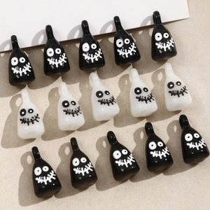 Close-up of black and white cartoon ghost resin charms with funny faces for DIY jewelry