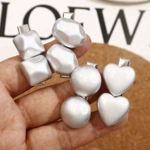 Close-up of shiny silver irregular geometric and heart-shaped DIY hair clip set