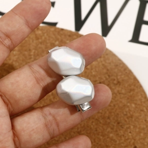 Macro view of geometric silver hair clip featuring faceted metallic polygon design