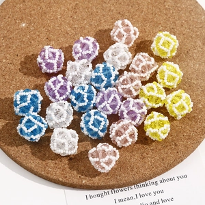 Detailed close-up of colorful handmade woven bead balls on a natural cork base
