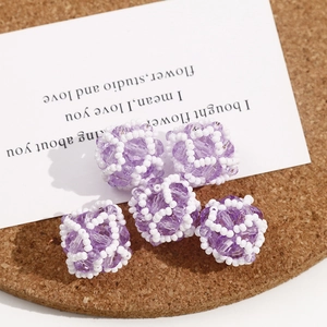 Macro shot of 5 pieces handmade woven beads with purple faceted crystal for jewelry DIY