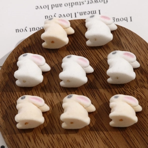 Detailed view of mini flocked bunny beads in white and beige for DIY jewelry crafting