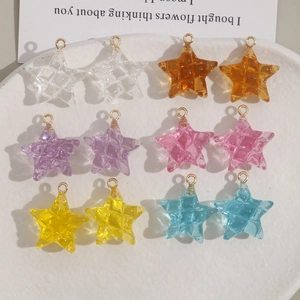Detail van kleurrijke sterrenharsbedeltjes met gouden lussen voor DIY-sieraden maken
