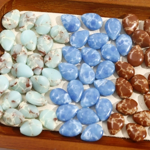 Polished teardrop-shaped stone beads in light blue, bright blue, and reddish brown colors