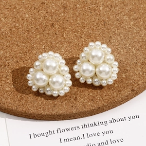 Detailed view of white faux pearl cluster stud earrings in a floral triangle shape