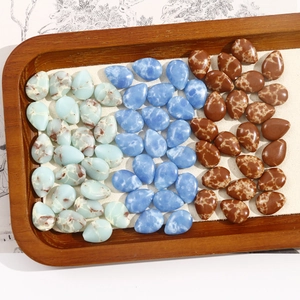 Macro detail of teardrop-shaped crackle texture beads in blue and brown on a tray