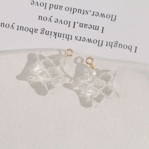Macro-opname van transparante ster-bedeltjes van hars met 3D-textuur en gouden ringen