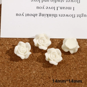 Detailed macro view of 14mm white flocked rose flower charms for DIY jewelry making