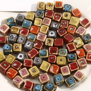 Macro shot of colorful glazed ceramic square beads with retro speckled kiln-change effect