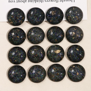 Macro detail of round black resin cabochons with glitter and gold foil for DIY jewelry