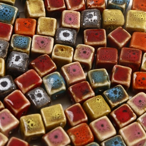 Close-up of geometric cube ceramic beads with colorful reactive glaze for jewelry making