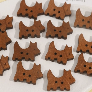 Macro shot of brown wooden dog-shaped buttons with two holes for DIY craft jewelry