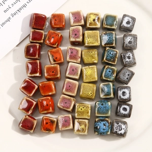 Macro shot of assorted colorful square ceramic beads for DIY jewelry in a white tray