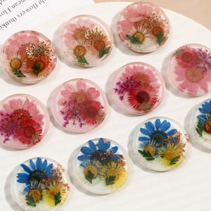 Detailed view of assorted resin charms with real dried flowers for DIY jewelry making