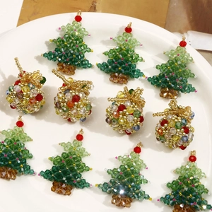 Detailed view of handmade Christmas tree and colorful beaded charms in a ceramic tray