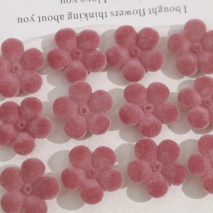 Vue détaillée de perles de fleurs en acrylique rose floqué pour bijoux DIY