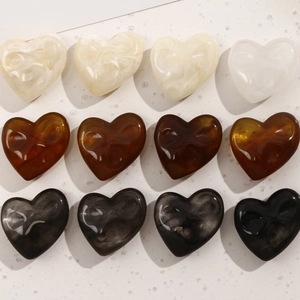 Macro detail of irregular heart-shaped resin charms with artistic ink marble texture