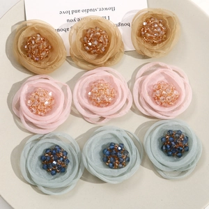 Close-up of nine mesh fabric roses with rhinestone centers for DIY hair accessories