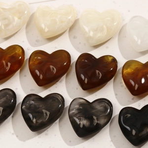 Detailed grid showing heart-shaped resin charms in creamy white, amber, and grey ink tones