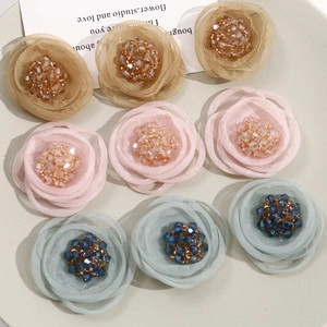 Detail of handmade mesh flower accessories with rhinestone centers for DIY hairpins