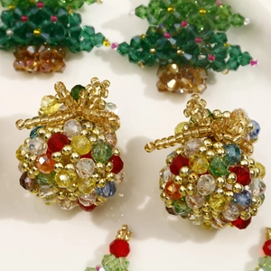 Macro shot of handmade crystal beaded Christmas tree and colorful gift bag charms