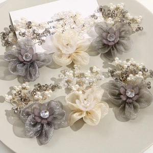 Handmade mesh flower jewelry accessories with pearls and crystals in a grey tray