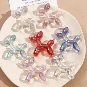 Detailed view of colorful iridescent acrylic balloon dog pendants in a ceramic tray