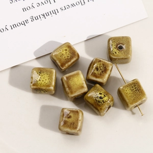 Macro shot of cubic ceramic beads with brown speckled glaze and through-hole for DIY jewelry