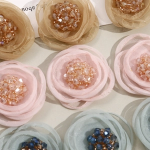 Detailed close-up of layered organza mesh flowers with sparkling crystal centers
