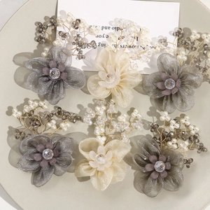 Detail of DIY mesh flower hair accessories with pearls and wire tassels in a tray