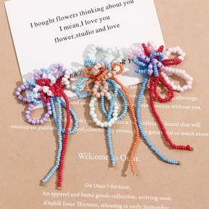 Detailed view of handmade beaded flower charms with long tassels for DIY accessories