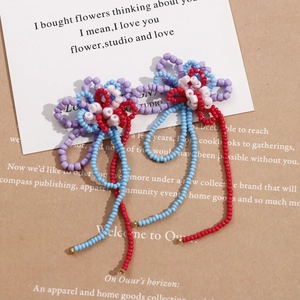 Detailed view of handmade beaded flower with colorful tassels and intricate weaving