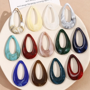 Detailed view of colorful teardrop acrylic pendants with marble textures for DIY jewelry making