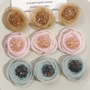Close-up of handmade mesh gauze flowers with sparkling beaded centers for accessories