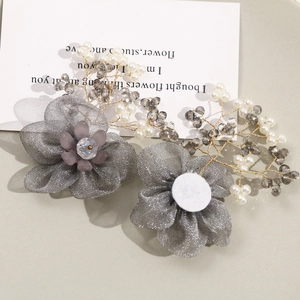 Detailed shot of handmade smoky grey mesh flower hairpins with pearls and crystals