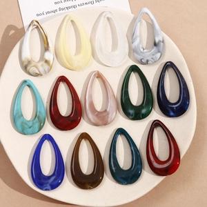 Flat lay of hollow teardrop acrylic charms in 12 assorted marble ink colors for DIY jewelry