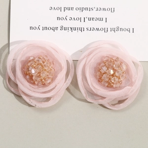 Detailed view of pink mesh fabric flower with delicate yellow beaded center for hair accessories