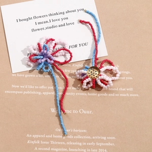 Macro view of handmade beaded flower jewelry with colorful tassels on a rustic paper background