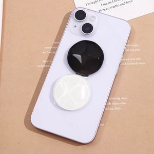 Close-up of black and white round phone grips with textured water ripple surface on phone