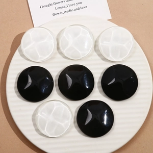 Macro shot of 40mm round resin charms with water ripple texture and polished black finish