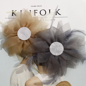 Close-up of handmade mesh flower hair accessories with soft feathers and crystal dots