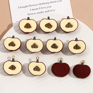 Detailed view of dark red resin apple charms with gold glitter core for DIY jewelry