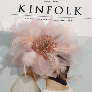 Macro detail of handmade pink mesh flower hair accessory with feathers and crystal beads