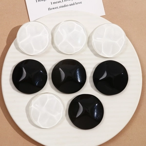 Detailed view of 40mm round resin charms with wave texture in black and white colors