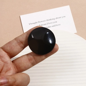 Detailed view of a 40mm round black glossy resin disc for DIY jewelry making and crafts