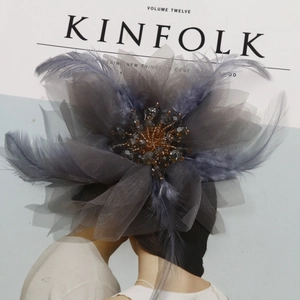 Close-up of handmade tulle flower hairpiece with soft feathers and crystal beads