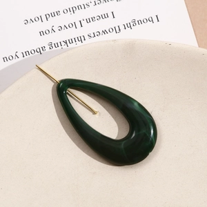 Detailed macro view of deep green marble acrylic teardrop charm with gold metal pin detail